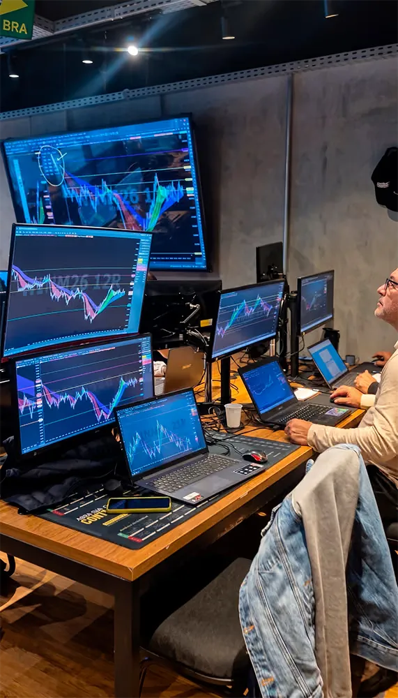 Mesa de operação com as telas e o pregão em tempo real